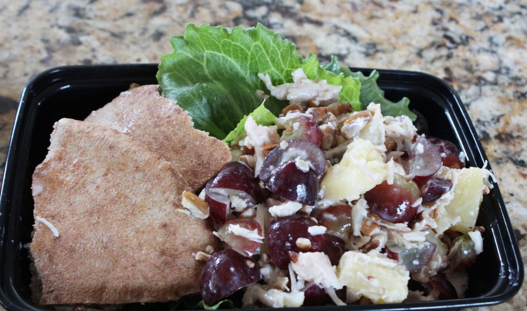 easy chicken salad shown meal prepped with lettuce and pita bread